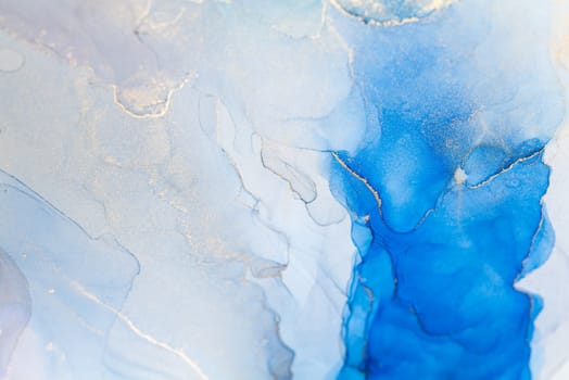 Blue and gold alcohol ink. Style incorporates the swirls of marble or the ripples of agate. Abstract painting, trendy background for wallpapers, posters, cards, invitations, websites.
