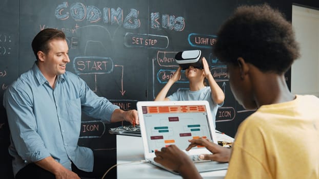 Girl wear VR glass and learning metaverse while instructor using electronic board. African student writing system while receive advice from teacher at table with electronic equipment. Edification.