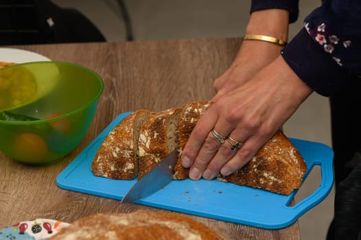 woman cutting freshly baked homemade bread in the kitchen 4