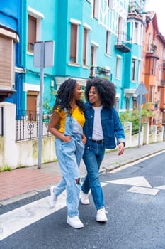 Vertical photo of a young african american couple walking together along a street with colorful facades
