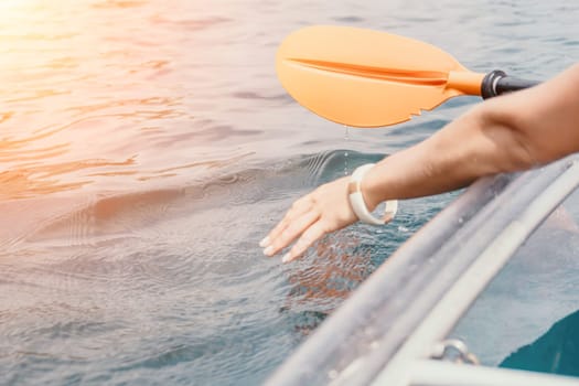 Woman in kayak back view. Happy young woman with long hair floating in transparent kayak on the crystal clear sea. Summer holiday vacation and cheerful female people having fun on the boat.