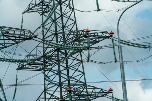 High voltage towers with sky background. Power line support with wires for electricity transmission. High voltage grid tower with wire cable at distribution station. Energy industry, energy saving.