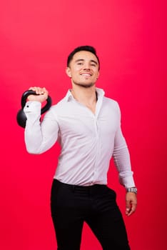 Attractive businessman Exercising With Kettlebell In a studio, red background