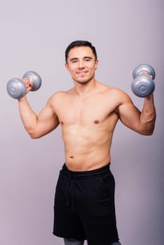 Shirtless bodybuilder showing his great body and holding dumbells.