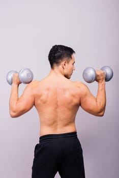 Shirtless bodybuilder showing his great body and holding dumbells.