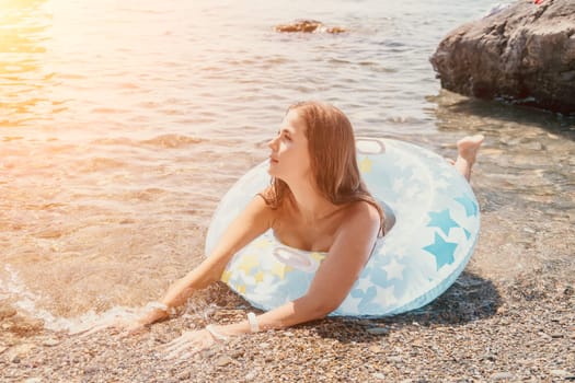 Woman summer sea. Happy woman swimming with inflatable donut on the beach in summer sunny day, surrounded by volcanic mountains. Summer vacation concept