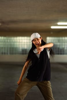 Cheerful young woman performing a Hip Hop dance in parking garage.