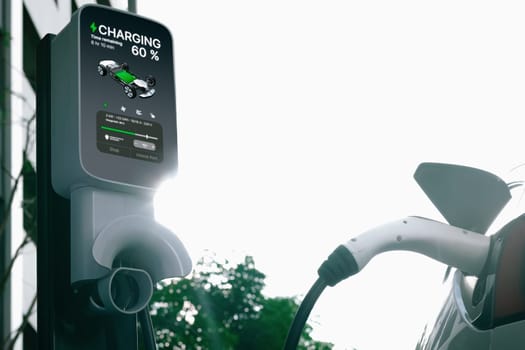 EV electric car charging in green sustainable city outdoor garden in summer. Urban sustainability lifestyle by green clean rechargeable energy of electric BEV vehicle innards