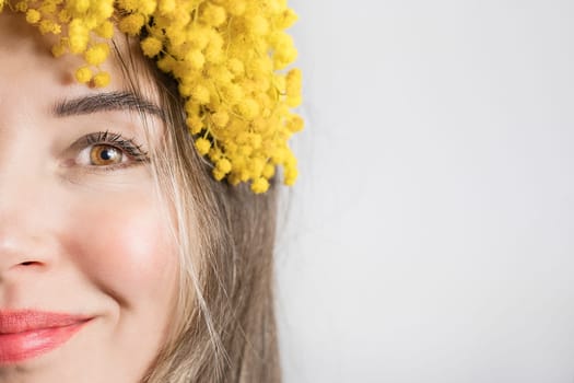 Portrait of Beautiful young woman with mimosa flowers on white background. Close up