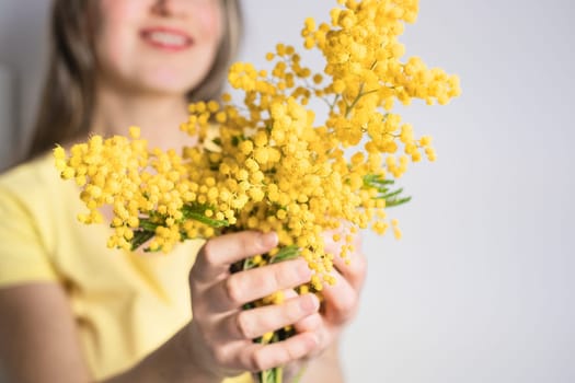 Beautiful young woman with mimosa flowers on white background. Close up