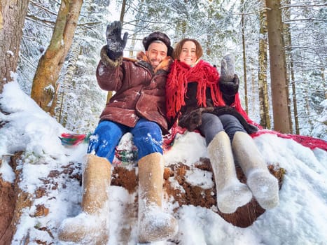 Cute middle-aged couple hugging in a snowy forest in winter. Photo shoot in stylized clothes of the USSR. Hat with earflaps, felt boots