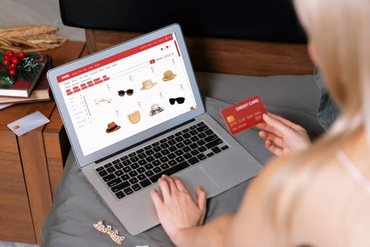 Young woman using laptop with credit card for internet banking, online shopping E commerce by online payment gateway at home. Modern and convenience online shopping with debit card. Blithe