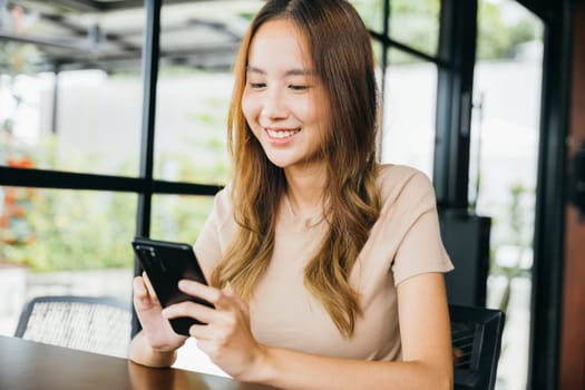 Asian young woman using smart phone for shopping online at cafe coffee shop in the morning, female has transfer money financial internet banking on mobile phone