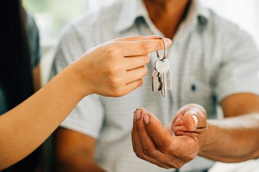 A cheerful couple displays keys to their new house symbolizing happiness and success in their real estate purchase. Reflecting joy achievement and excitement in homeownership.
