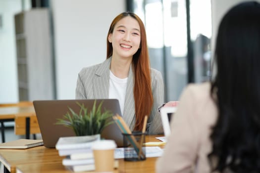 Two business professionals engaged in a serious discussion, possibly conducting a job interview in a modern office environment.