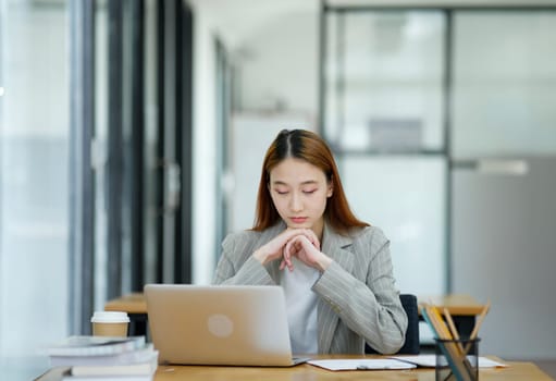 Female employees are stressed and tired. Headache from thinking and pressure from work.