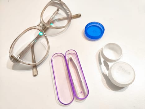 Set for contact lenses with a container, forceps, glasses. The concept of correcting myopia. Contact lens care, cleaning, health. Background, copy space