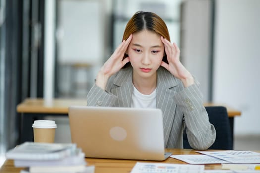 Female employees are stressed and tired. Headache from thinking and pressure from work.