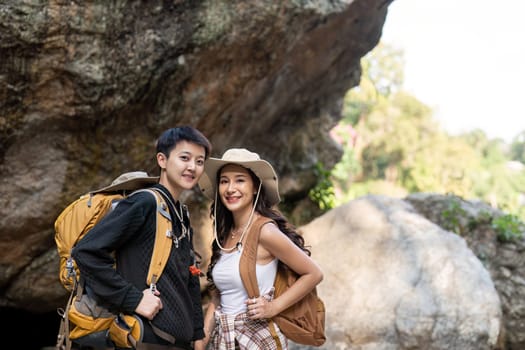 Lovely couple lesbian woman with backpack hiking in nature. Loving LGBT romantic moment in mountains.