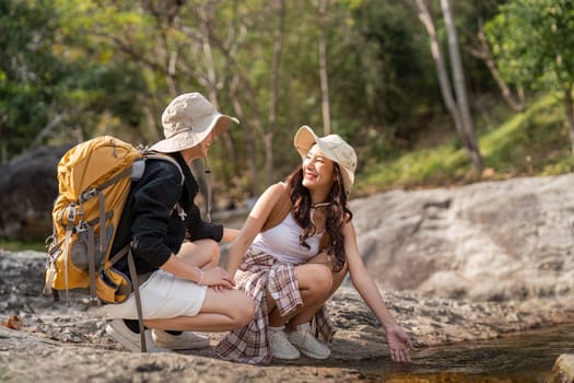 Lovely couple lesbian woman with backpack hiking in nature. Loving LGBT romantic moment in mountains.