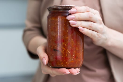 jar tomato paste in hand isolated on white background. High quality photo