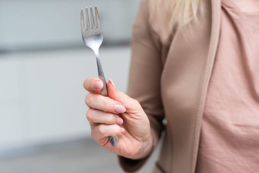 Fork in a hand on a white background isolation. High quality photo