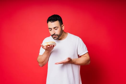 Man holding freshly baked bread in hands isolated on a red background