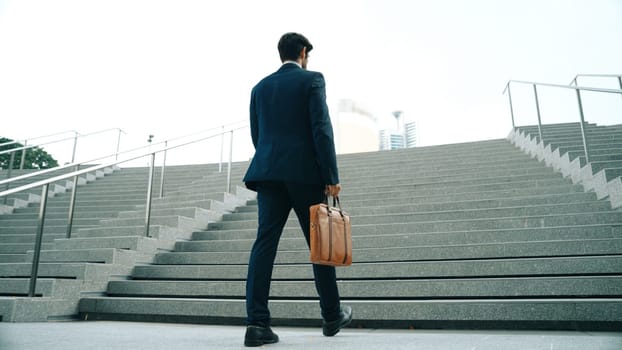 Top view of smart business man walking up stairs with bag in the hand. Professional project manager climb up the stair and going to workplace. Increasing skill, getting promotion, traveling. Exultant.