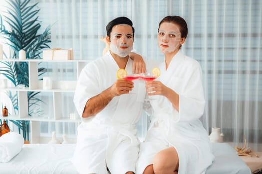 Serene modern daylight ambiance of spa salon, couple customer indulges in rejuvenating with facial skincare mask. Facial skin treatment and beauty cosmetology procedure for face. Quiescent