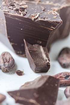 Cocoa beans with chocolate on a white background. Shalllow dof. Top view