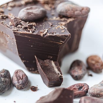 Cocoa beans with chocolate on a white background. Shalllow dof. Top view