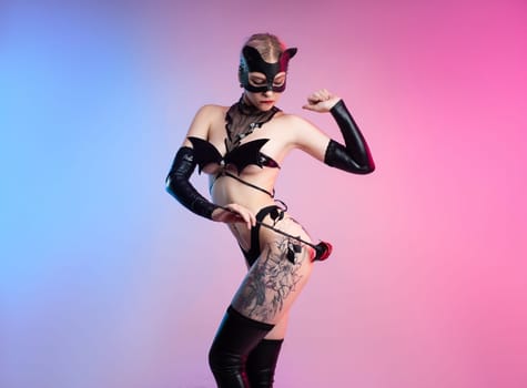 Sexy girl in lingerie, leather cat mask for BDSM costume for sex games on a pink bright background copy paste