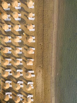 Aerial view fly along sea coast with empty sun beds. High quality photo