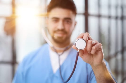 A futuristic doctor shows stethoscope and appear of advanced futuristic medicine symbols in holography.