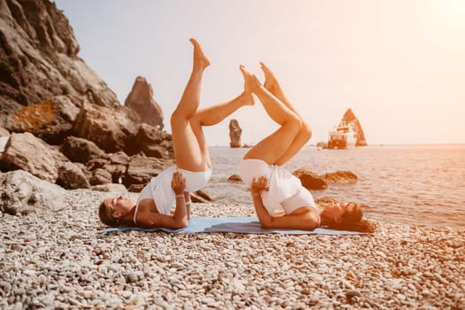 Woman sea yoga. Back view of free calm happy satisfied woman with long hair standing on top rock with yoga position against of sky by the sea. Healthy lifestyle outdoors in nature, fitness concept.