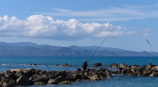 Gaziveren/Cyprus-05.02.2024: fisherman catches fish in the mediterranean sea