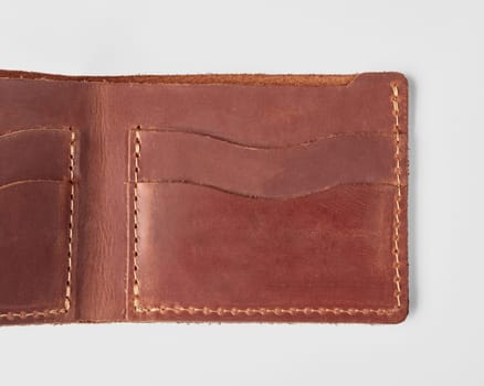 Closeup of open brown leather mens wallet with pockets for card and driver license and hidden embossed message for personal touch. Stylish option for individual gift