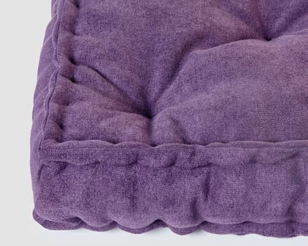 Macro shot showcasing rich texture and softness of luxurious purple velvet cushion on white background, perfect for modern interior accents