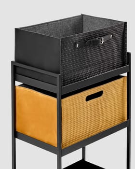 Two stylish black leather and yellow suede woven storage bins with convenient handles arranged on metal office trolly. Craft accessories for comfortable organization of space