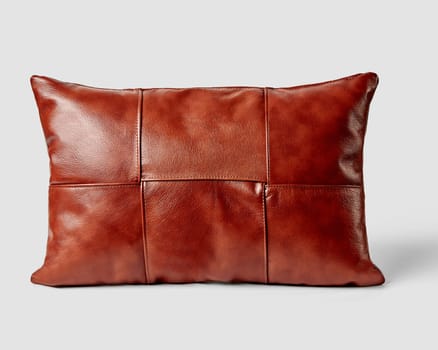 Stylish brown leather sofa pillow with elegant stitched detailing, presented against neutral background. Artisan accessory for interior design