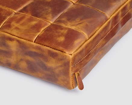 Closeup of decorative seat cushion made of patches of brown leather with hook-and-loop fastener for comfort and stylish home interior design. Artisanal genuine leather products