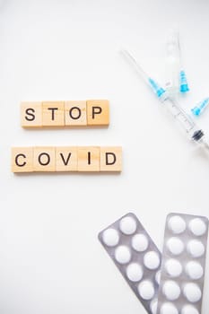 Stop coronavirus inscription. Preparation for vaccination against covid-19. Syringe, vaccine, pills, medical mask