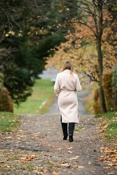 A young girl in an autumn park on a photo shoot, a theme for an autumn calendar, a happy girl in a park.