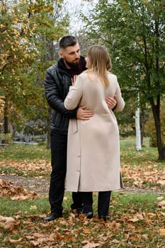 Portrait of a man and a woman in an autumn park, a couple in love in the park.