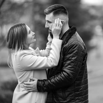 Portrait of a man and a woman in an autumn black and white park, a couple in love in the park.