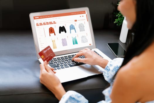 Young woman using laptop with credit card for internet banking, online shopping E commerce by online payment gateway at home. Modern and convenience online shopping with debit card. Blithe