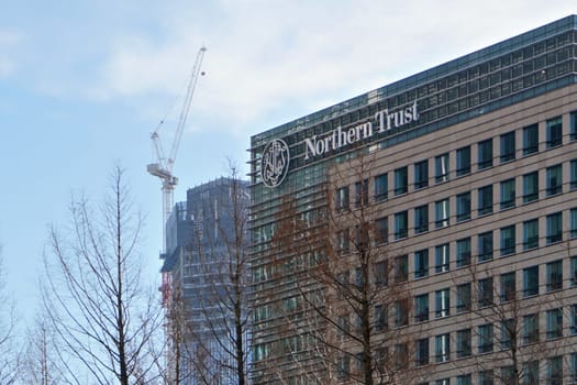 London, United Kingdom - February 03, 2019: Northern Trust UK branch offices at Canary Wharf. Tall construction crane in background. NT corporation is financial services company founded in 1889
