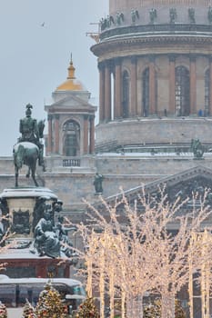 Russia, St Petersburg, 30 December 2023: people walk among Christmas trees in heavy snowfall, a park organized on holidays near St. Isaac's Cathedral and the monument to Emperor Nicholas II. High quality 4k footage