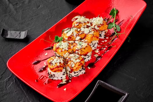 Exquisite sushi rolls topped with seared cheese and seafood caps sprinkled with sesame and grated parmesan, garnished with greens on red plate. Fusion of Italian and Japanese culinary cultures