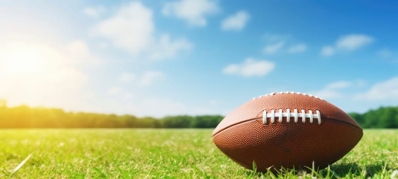 An American football placed on a green grass field with a bright and sunny sky in the background, symbolizing sports and outdoor activities.